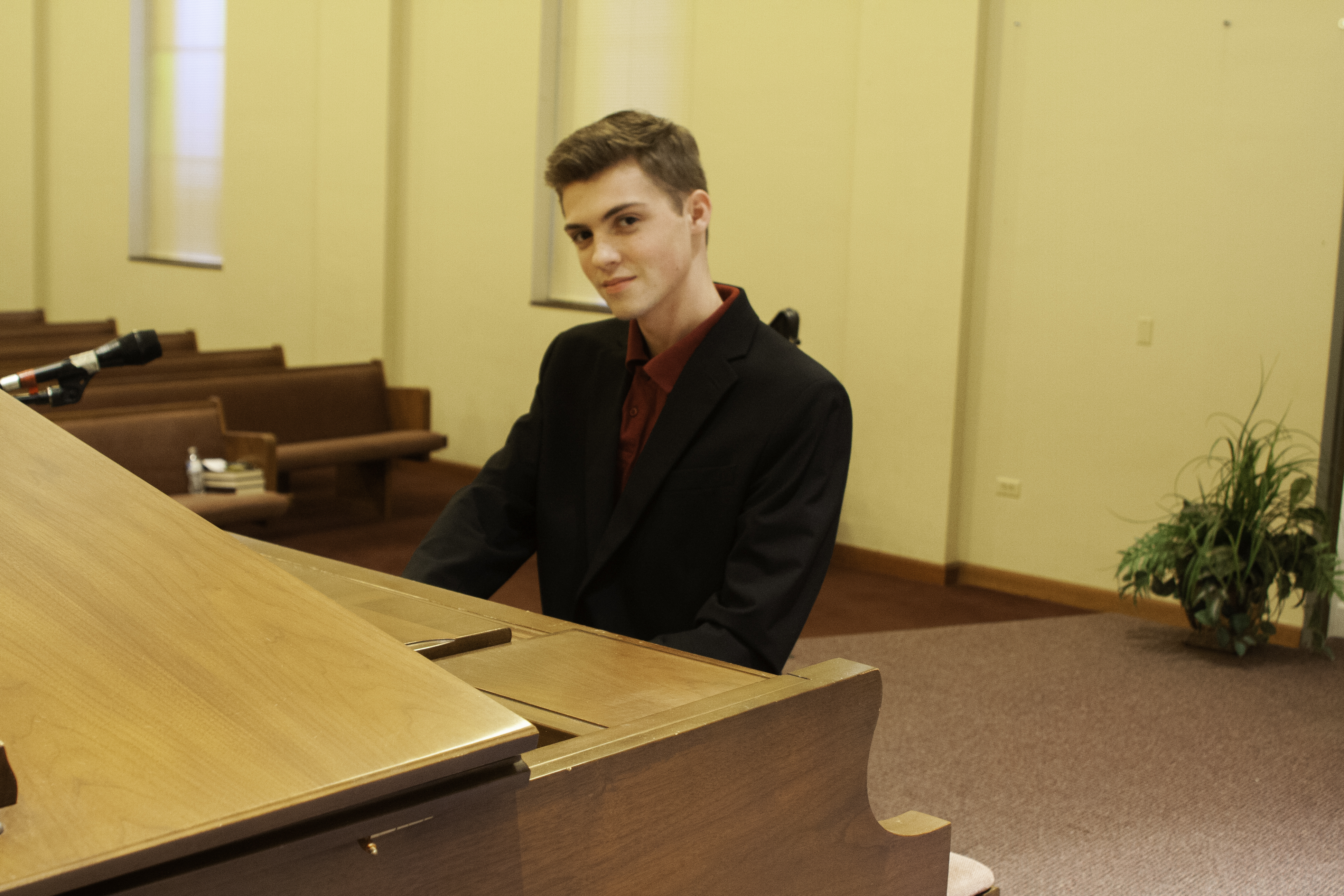 young man playing a grand piano